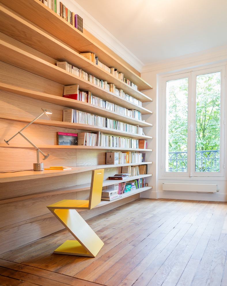Ejemplo de despacho contemporáneo de tamaño medio con paredes blancas, suelo de madera en tonos medios y escritorio empotrado