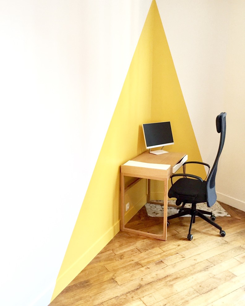 Foto de despacho escandinavo con paredes amarillas, suelo de madera clara, escritorio independiente y suelo marrón