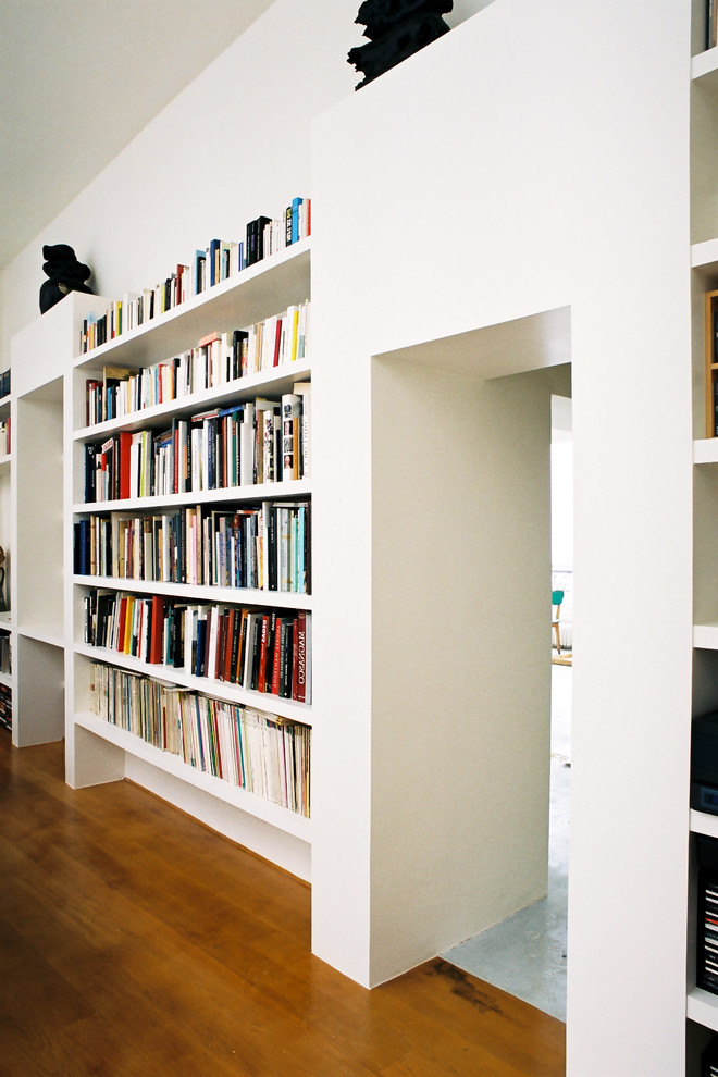 Idee per uno studio design di medie dimensioni con libreria, pareti bianche, pavimento in legno massello medio, nessun camino e scrivania autoportante