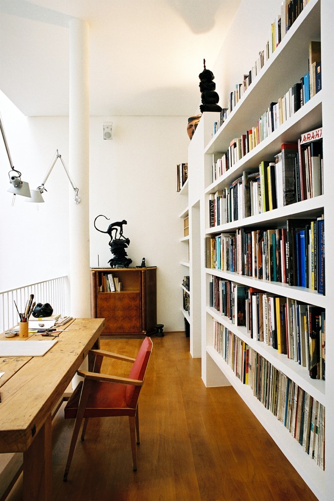 Exemple d'un bureau tendance de taille moyenne avec un mur blanc, un sol en bois brun, aucune cheminée, un bureau indépendant et une bibliothèque ou un coin lecture.