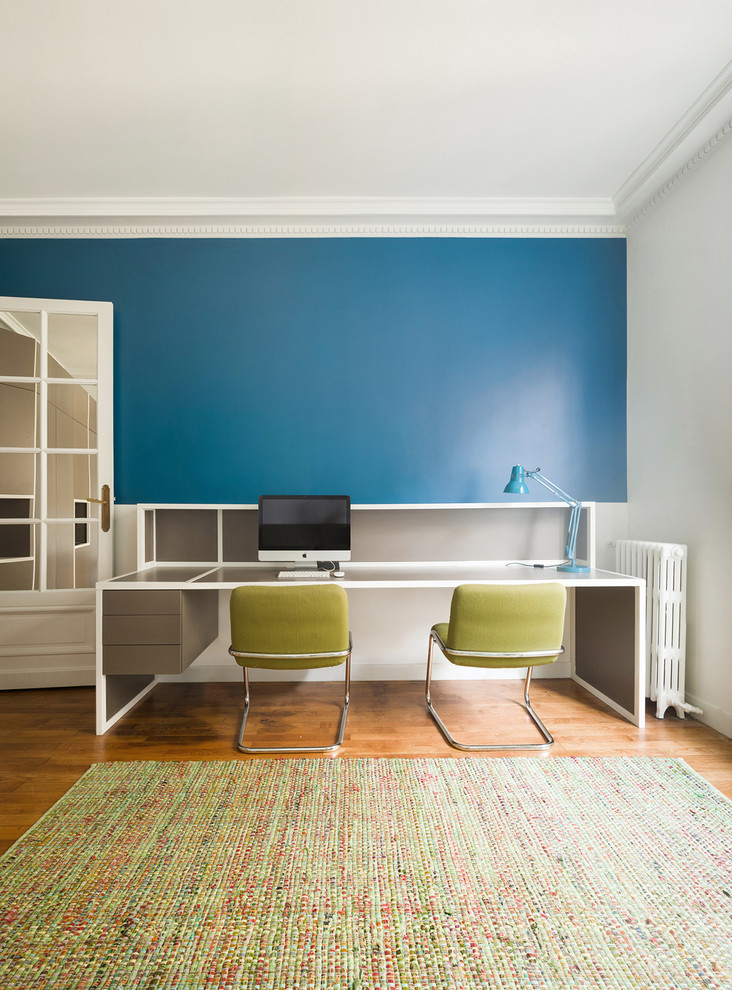 Idee per un ufficio minimal di medie dimensioni con pareti blu, pavimento in legno massello medio, scrivania autoportante e pavimento marrone