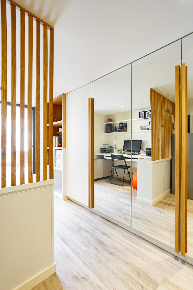 Immagine di un piccolo ufficio contemporaneo con pareti bianche, pavimento in linoleum, scrivania incassata e pavimento marrone