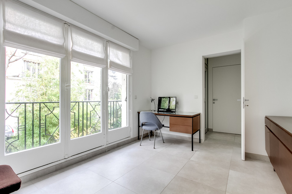 Идея дизайна: кабинет среднего размера в стиле неоклассика (современная классика) с белыми стенами, полом из керамической плитки, отдельно стоящим рабочим столом и серым полом
