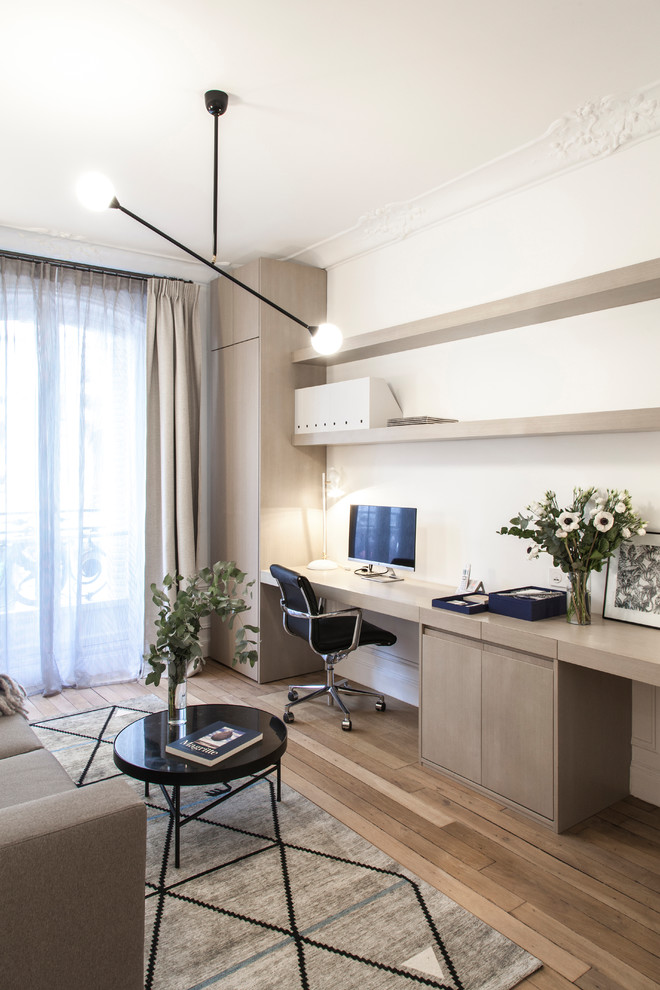 Diseño de despacho contemporáneo de tamaño medio sin chimenea con paredes blancas, escritorio empotrado, suelo de madera en tonos medios y suelo marrón