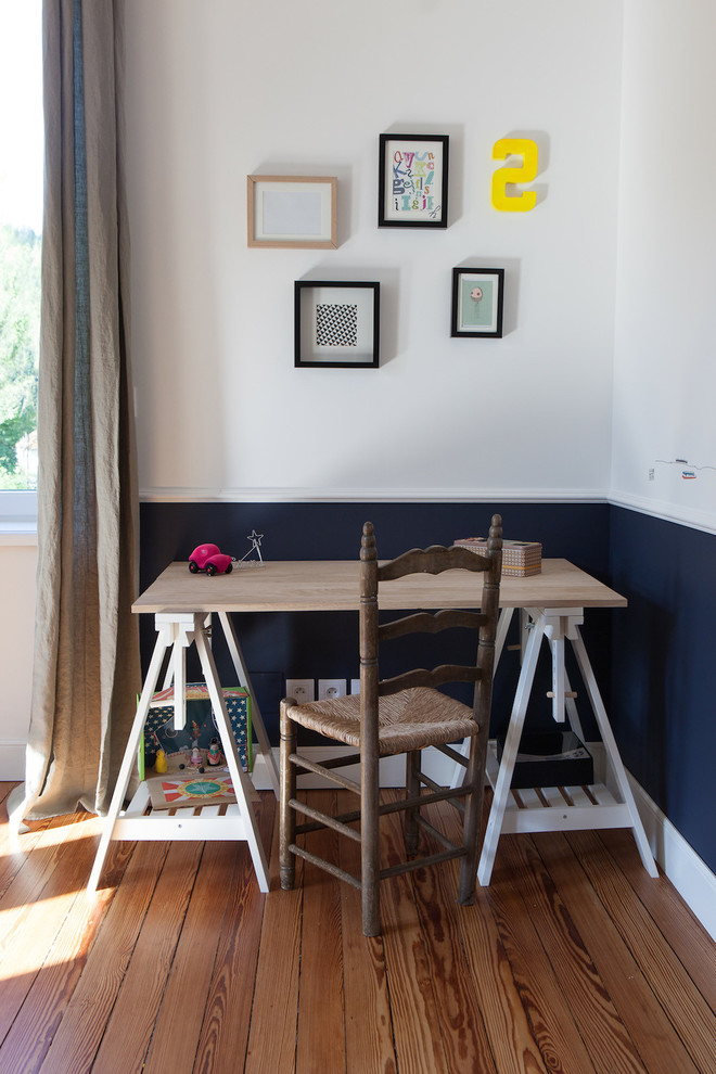 Diseño de despacho nórdico pequeño con paredes blancas, suelo de madera en tonos medios y escritorio independiente