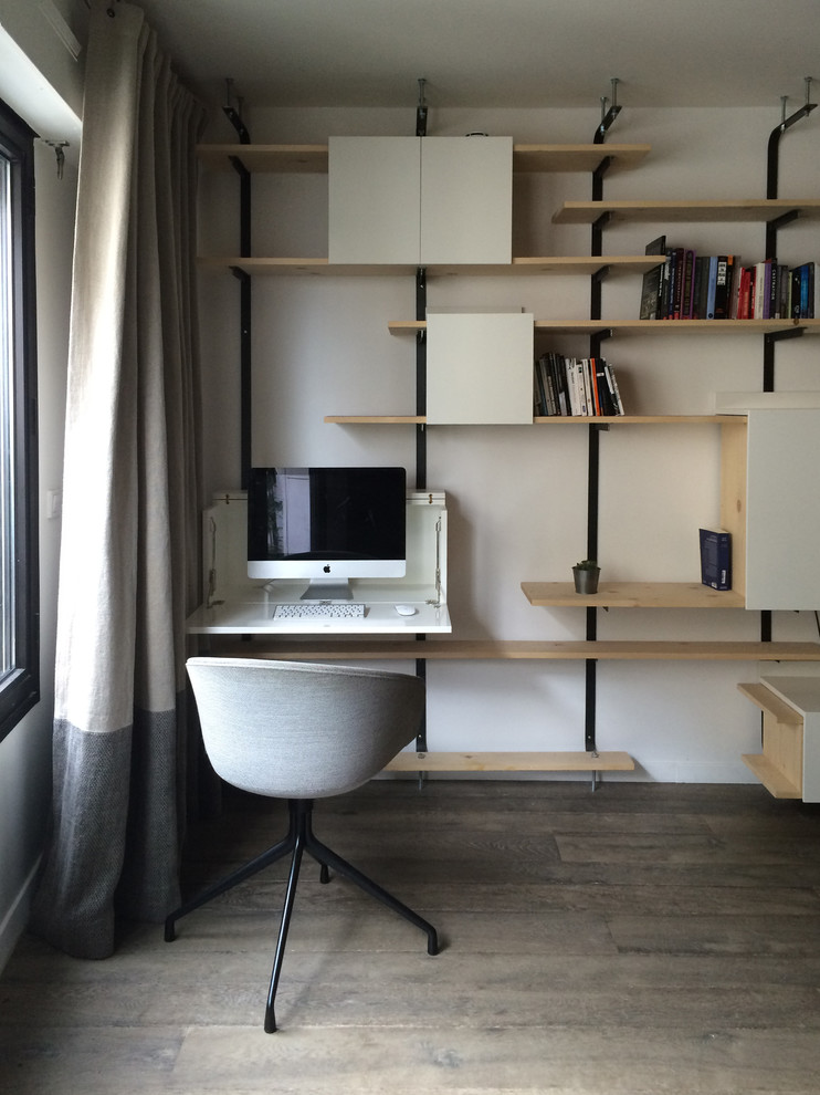 Modernes Arbeitszimmer ohne Kamin mit Arbeitsplatz, weißer Wandfarbe, braunem Holzboden und Einbau-Schreibtisch in Paris