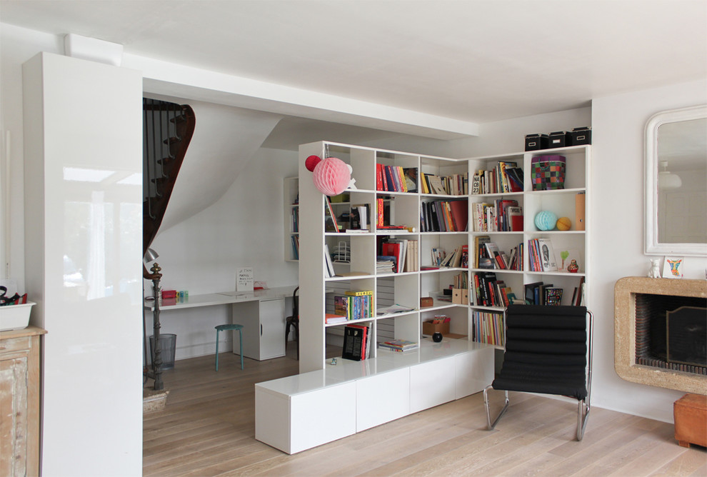 Inspiration för ett mellanstort eklektiskt hemmabibliotek, med vita väggar, mellanmörkt trägolv, en standard öppen spis, en spiselkrans i sten och ett fristående skrivbord