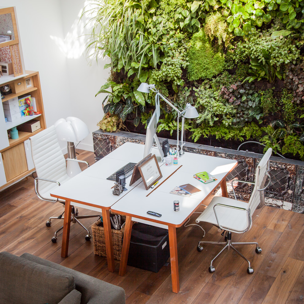 Großes Stilmix Arbeitszimmer mit Arbeitsplatz, weißer Wandfarbe, braunem Holzboden und freistehendem Schreibtisch in Paris
