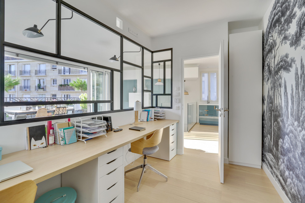 Großes Modernes Arbeitszimmer ohne Kamin mit Arbeitsplatz, weißer Wandfarbe, braunem Holzboden, Einbau-Schreibtisch, braunem Boden und Tapetenwänden in Paris