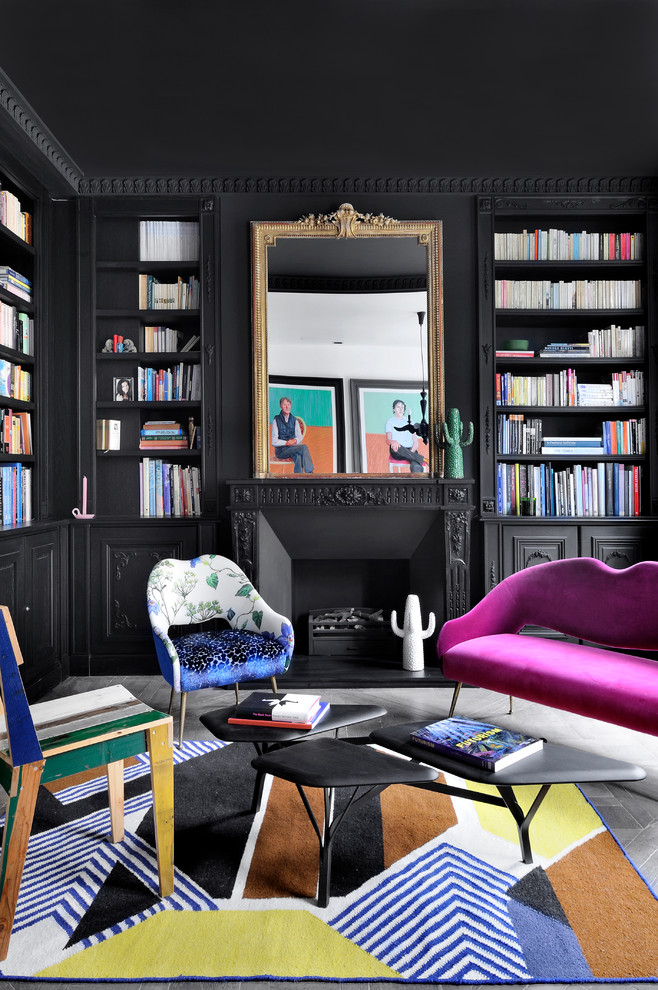 Medium sized bohemian home office in London with a reading nook, black walls, a standard fireplace, a metal fireplace surround and grey floors.