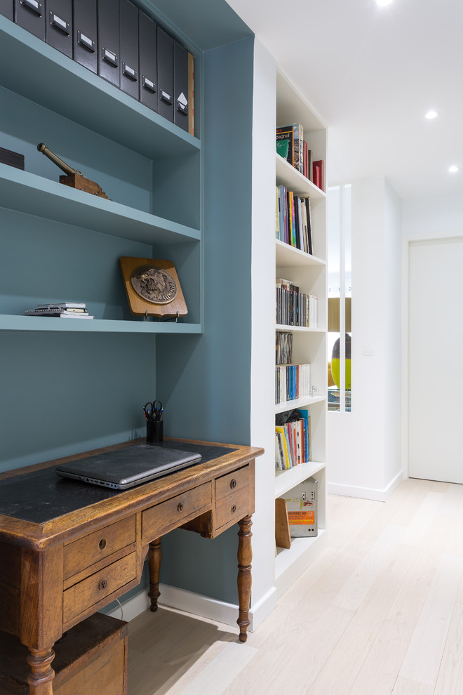 На фото: маленький домашняя библиотека в скандинавском стиле с синими стенами, светлым паркетным полом и отдельно стоящим рабочим столом для на участке и в саду с
