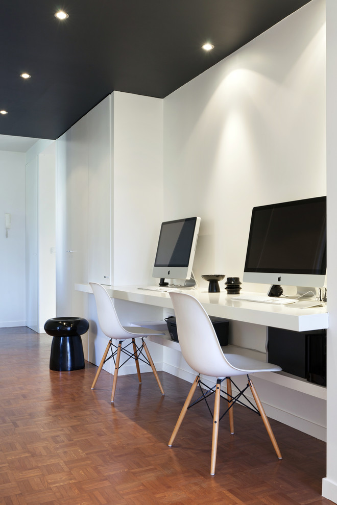 Idee per un ufficio minimal di medie dimensioni con pareti bianche, parquet scuro, nessun camino e scrivania incassata