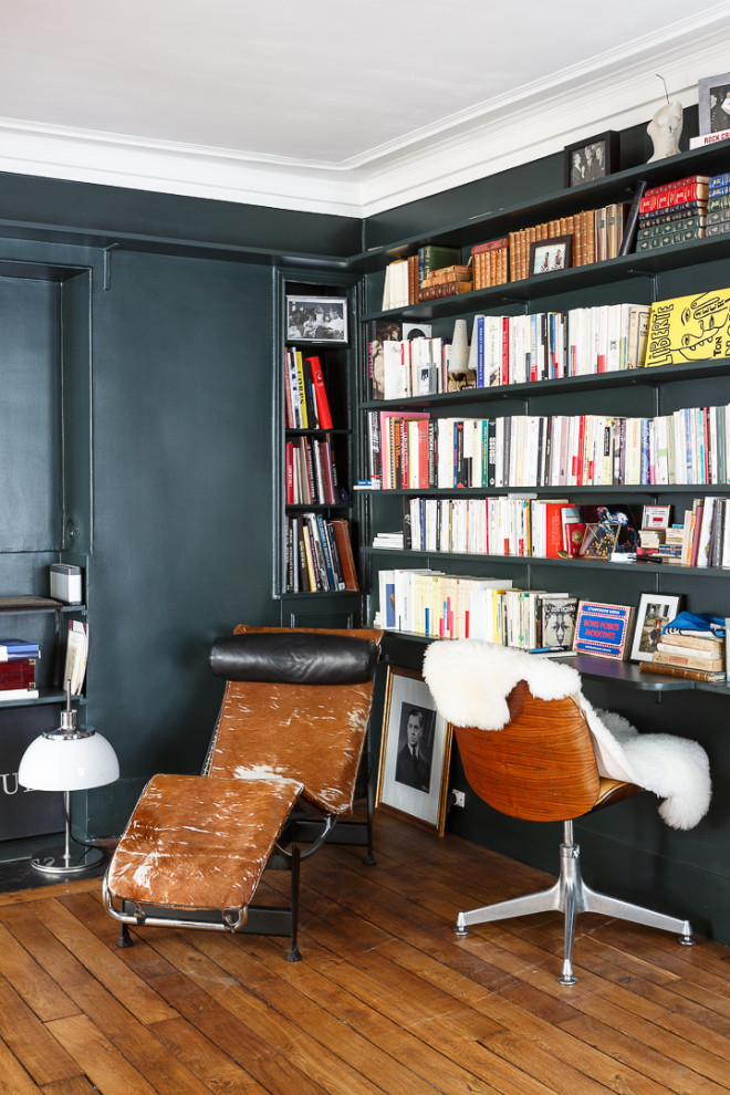 Cette photo montre un bureau chic de taille moyenne avec une bibliothèque ou un coin lecture, un mur bleu, un sol en bois brun, aucune cheminée, un bureau intégré et un sol marron.
