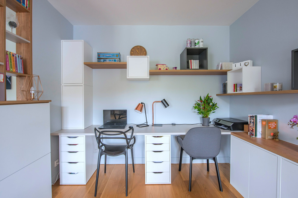Exemple d'un grand bureau tendance avec un mur gris et un bureau intégré.