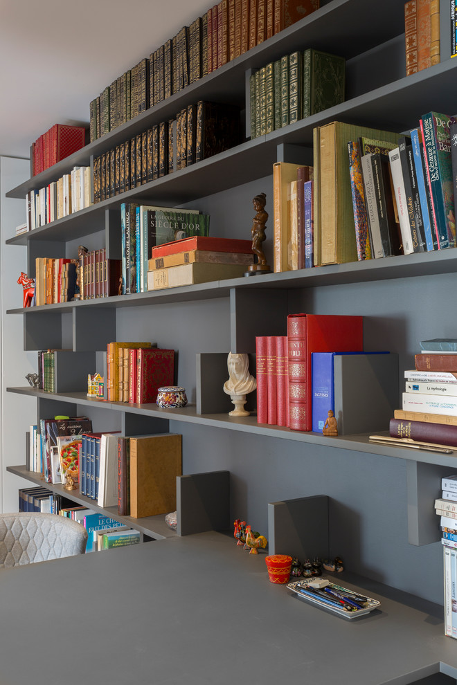 Exemple d'un petit bureau tendance avec une bibliothèque ou un coin lecture, un mur gris, parquet clair, aucune cheminée, un bureau intégré et un sol beige.