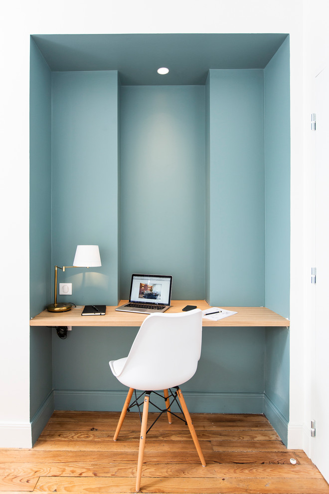 Ejemplo de despacho contemporáneo con paredes azules, suelo de madera en tonos medios, escritorio empotrado y suelo marrón