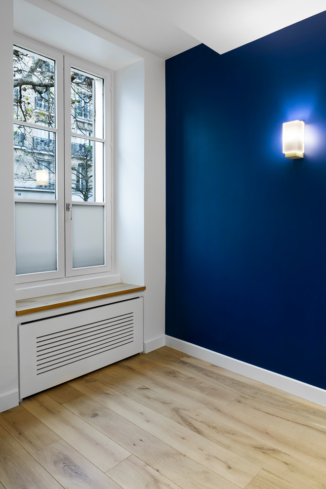 Idee per un ufficio contemporaneo di medie dimensioni con pareti blu, parquet chiaro e scrivania autoportante