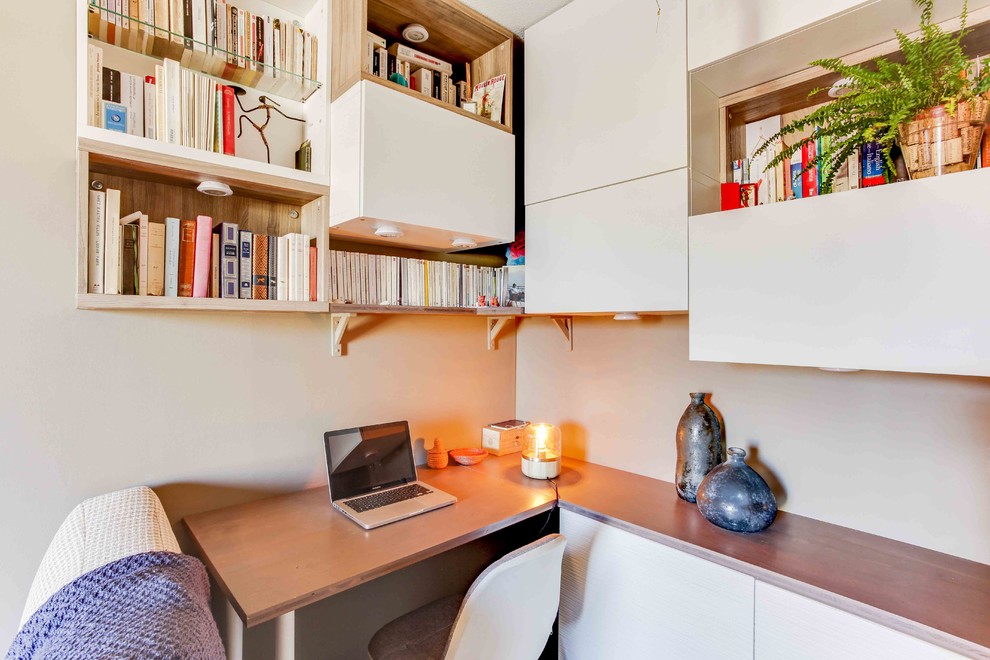 Aménagement d'un bureau contemporain de taille moyenne avec une bibliothèque ou un coin lecture, un mur beige, un sol en bois brun, aucune cheminée et un bureau intégré.