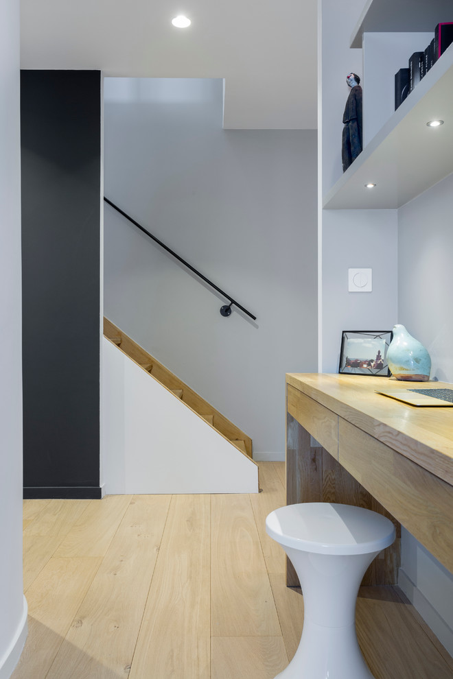 Foto di un piccolo ufficio minimal con pareti grigie, parquet chiaro e scrivania incassata
