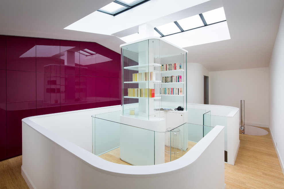 Aménagement d'un grand bureau contemporain avec un mur blanc, parquet clair et un bureau intégré.
