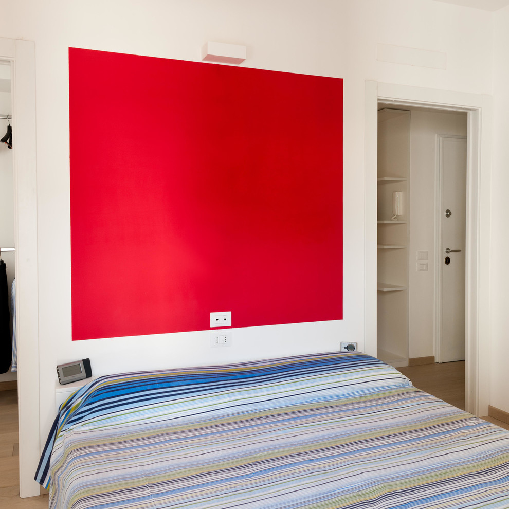 Diseño de dormitorio principal contemporáneo de tamaño medio con paredes rojas, suelo de madera clara y suelo marrón