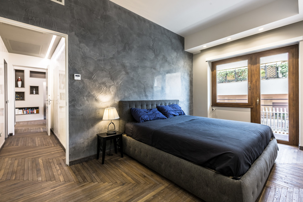 Foto de dormitorio principal contemporáneo con paredes grises, suelo de madera oscura y suelo marrón