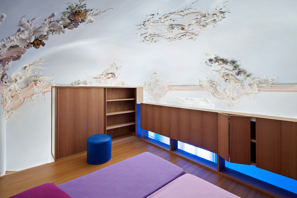 Ispirazione per una piccola camera da letto stile loft minimal con pavimento in legno massello medio