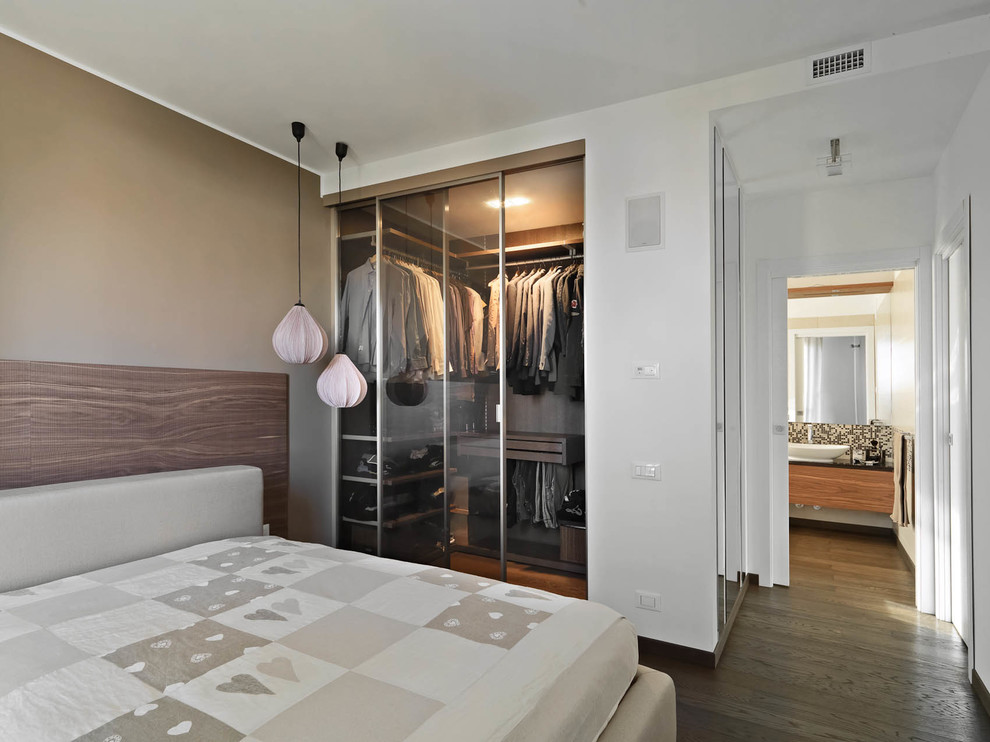 Modelo de dormitorio principal actual con paredes blancas y suelo de madera en tonos medios