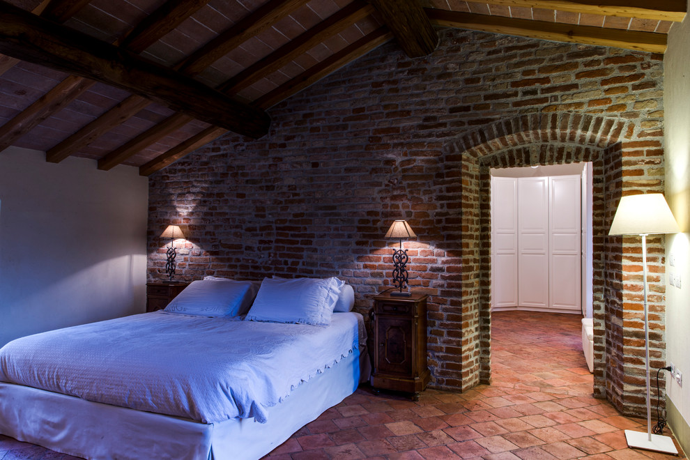 Стильный дизайн: спальня в стиле кантри с бежевыми стенами, полом из терракотовой плитки и красным полом - последний тренд
