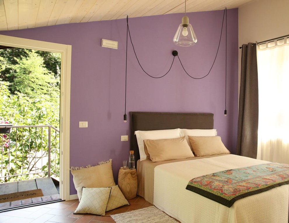 Ispirazione per una camera da letto country con pareti viola e pavimento marrone