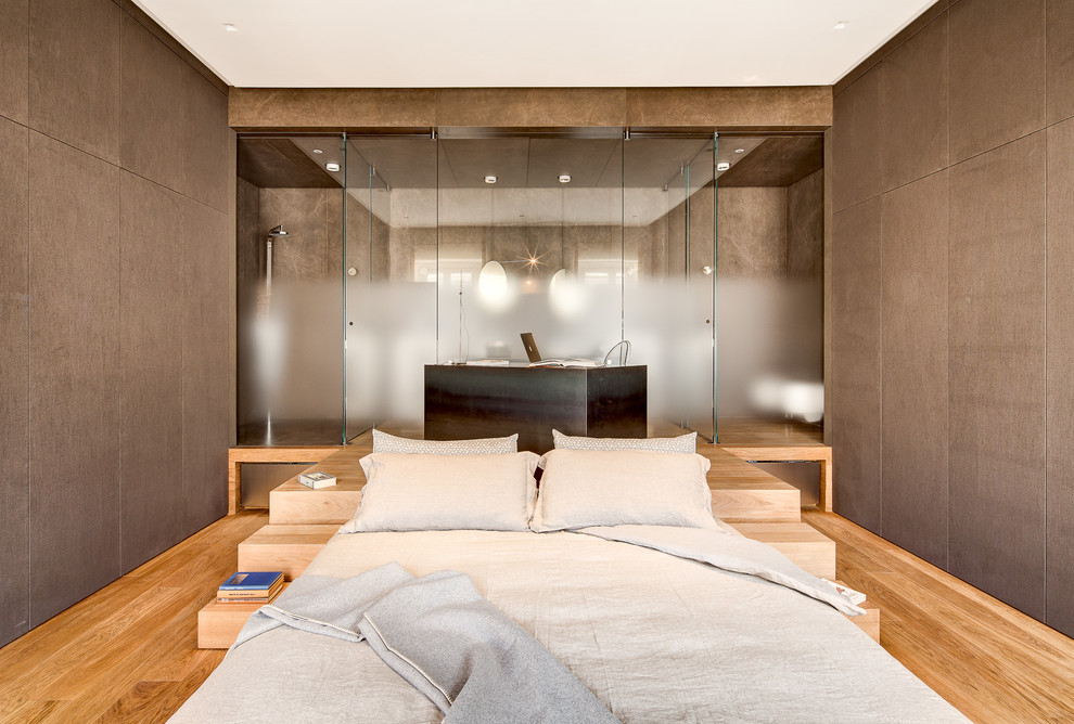 Modelo de dormitorio contemporáneo con paredes marrones y suelo de madera clara