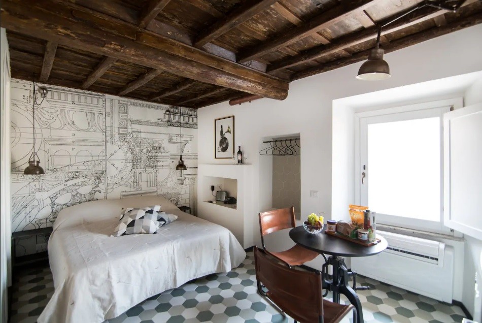 This is an example of a medium sized urban master bedroom in Rome with white walls, porcelain flooring and green floors.