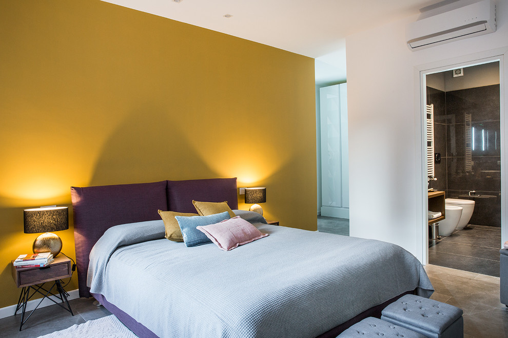 Ejemplo de dormitorio principal actual pequeño con paredes amarillas y suelo gris