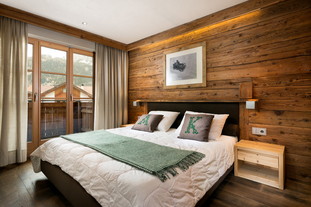 Foto de dormitorio principal rural de tamaño medio con suelo de madera oscura y paredes marrones