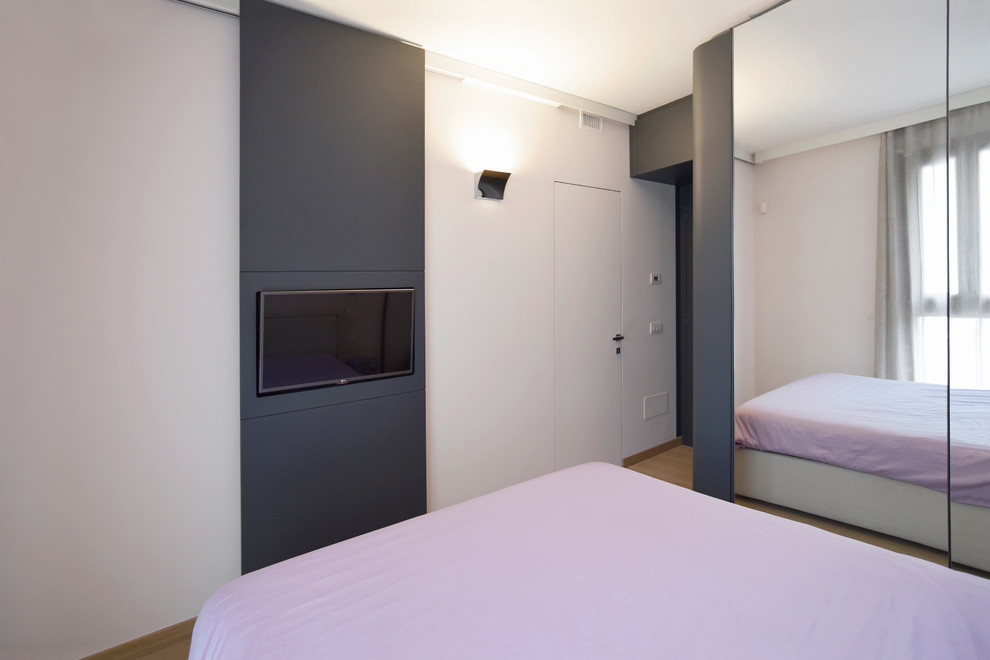 Imagen de dormitorio principal contemporáneo pequeño con paredes rosas y suelo de madera clara