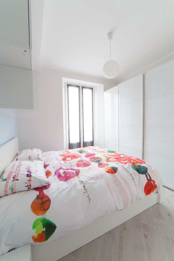 Idéer för ett litet modernt sovrum, med vita väggar och klinkergolv i porslin