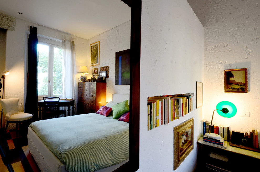 Idée de décoration pour une petite chambre parentale bohème avec un mur blanc et parquet peint.