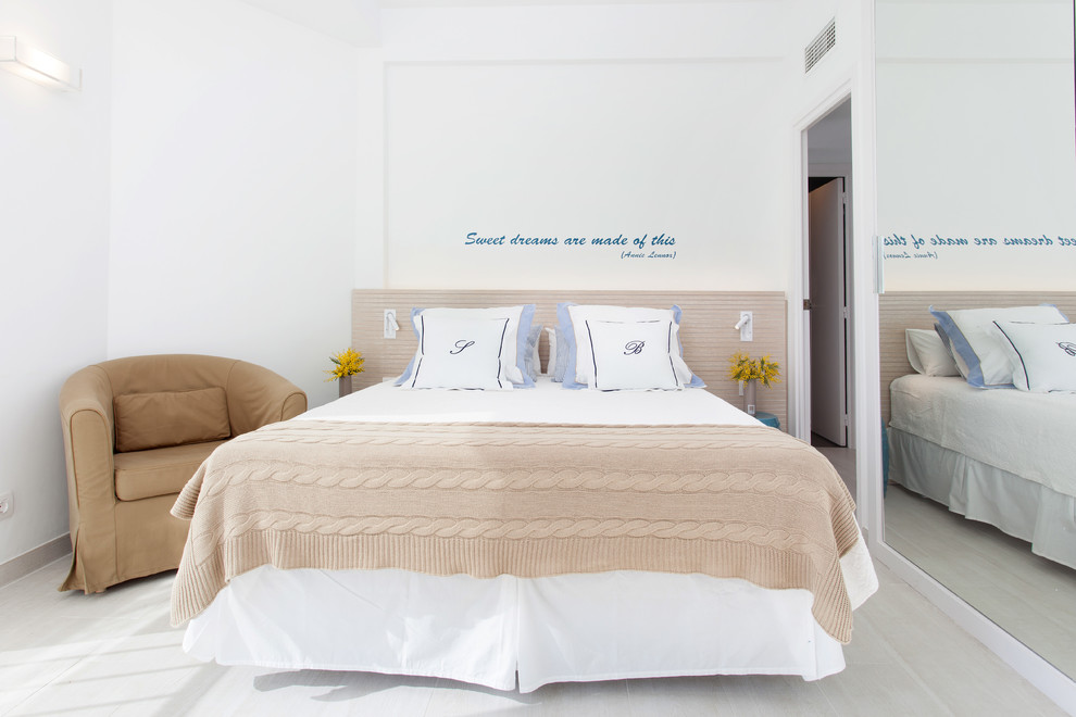 Modelo de dormitorio principal costero de tamaño medio sin chimenea con paredes blancas
