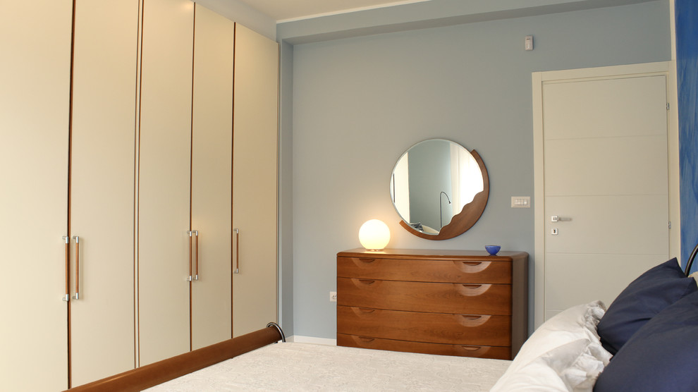 バーリにある広いコンテンポラリースタイルのおしゃれな主寝室 (青い壁、磁器タイルの床) のレイアウト