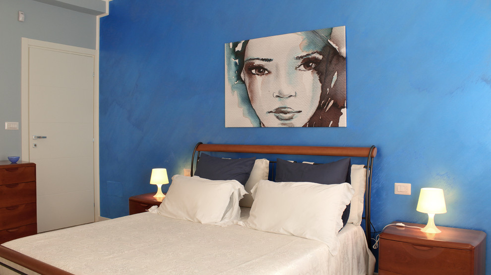 Imagen de dormitorio principal actual grande con paredes azules y suelo de baldosas de porcelana