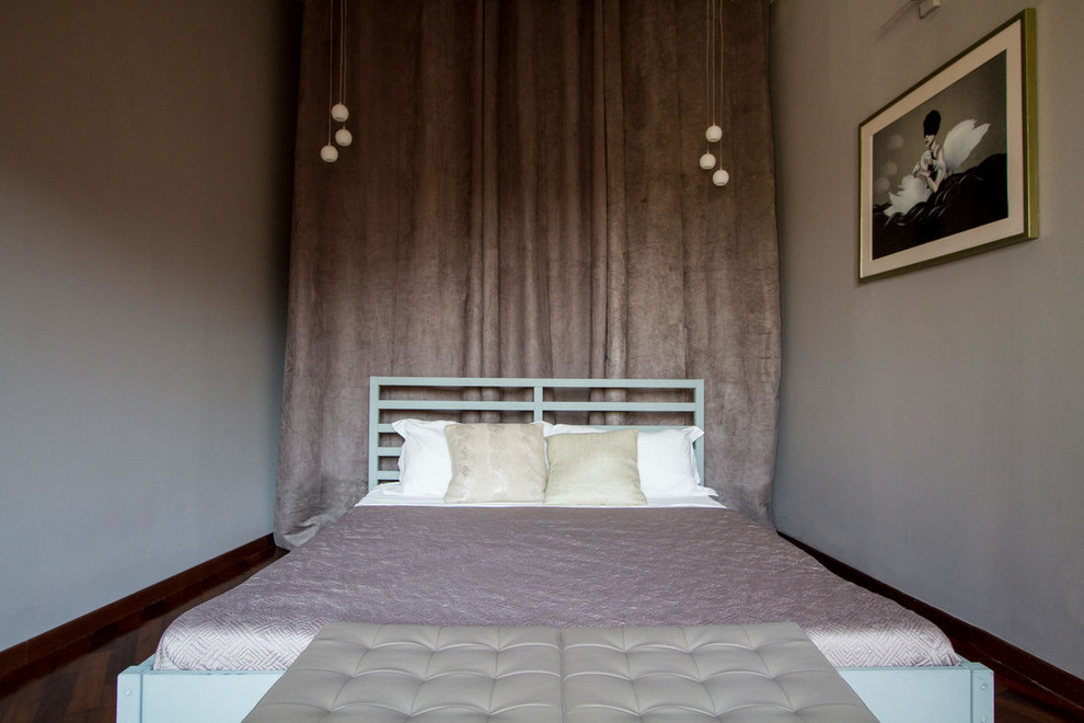 Réalisation d'une petite chambre d'amis minimaliste avec un mur violet, un sol en bois brun et un sol marron.