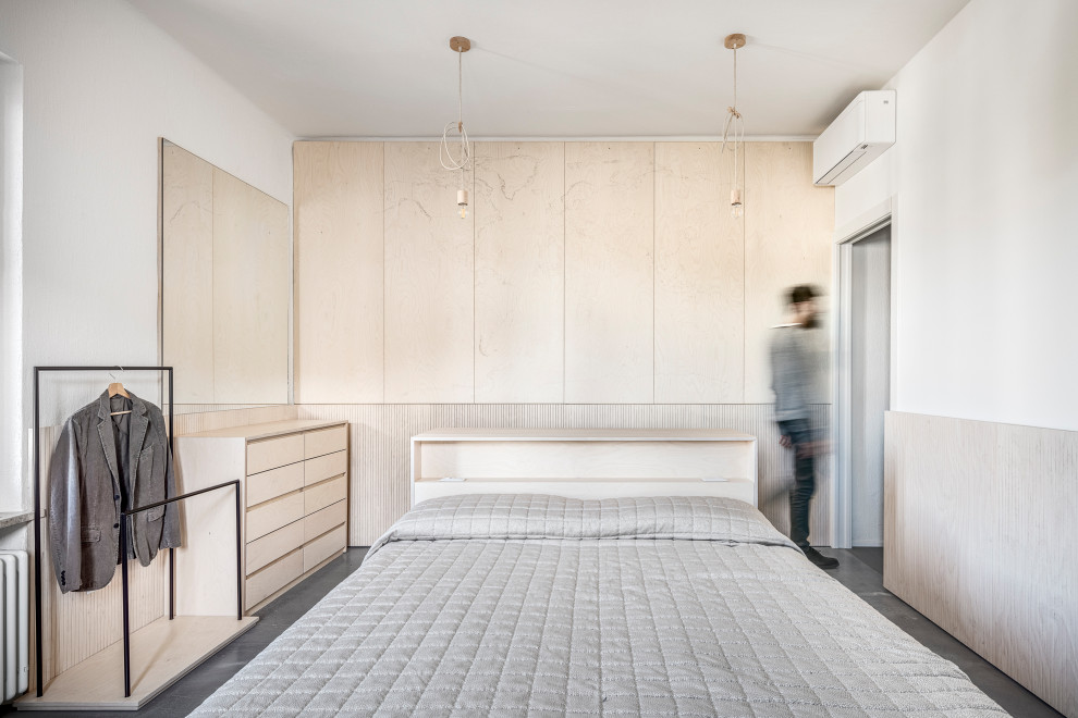 На фото: хозяйская спальня среднего размера в современном стиле с белыми стенами, бетонным полом и серым полом с