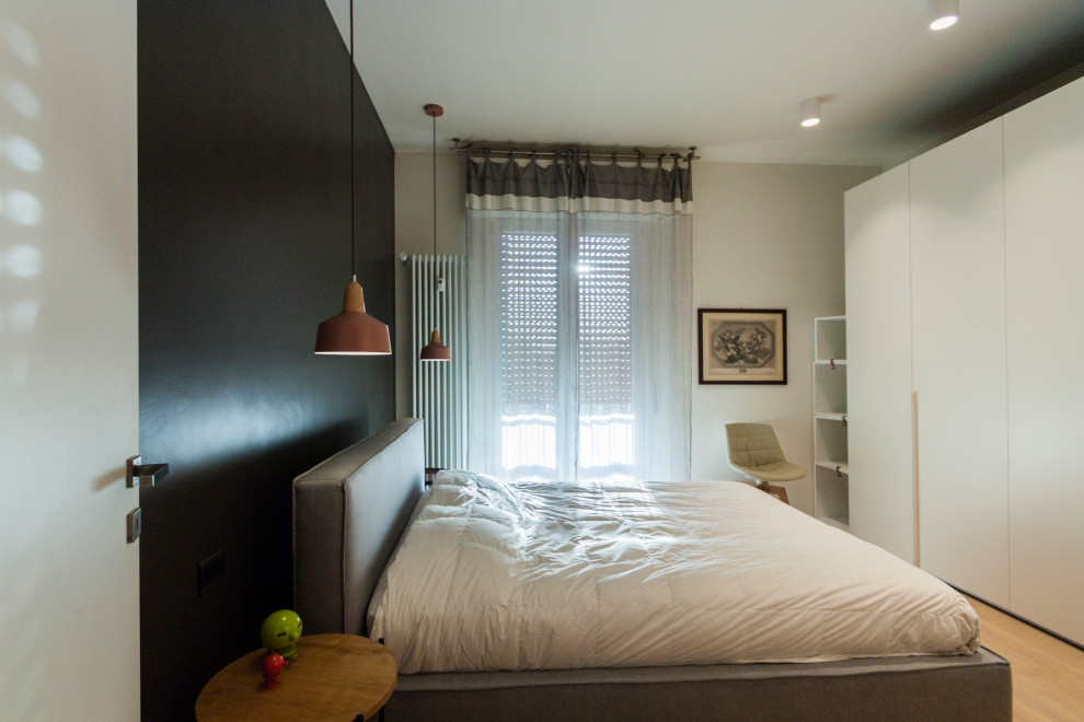 Immagine di una grande camera da letto minimal con pareti beige e parquet chiaro