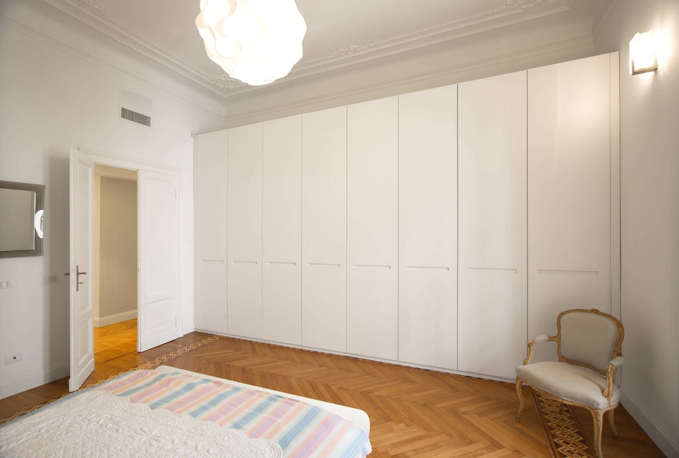 Esempio di una grande camera matrimoniale minimal con pareti bianche e pavimento in legno massello medio