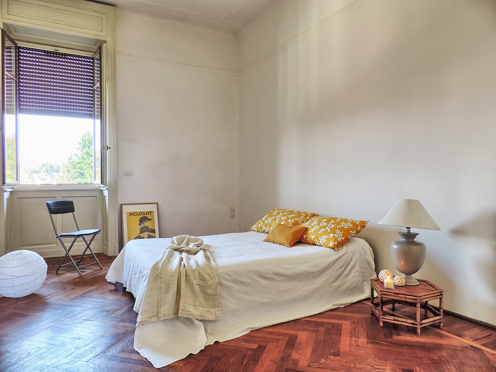 Foto di una camera matrimoniale bohémian con pareti bianche e pavimento in legno massello medio