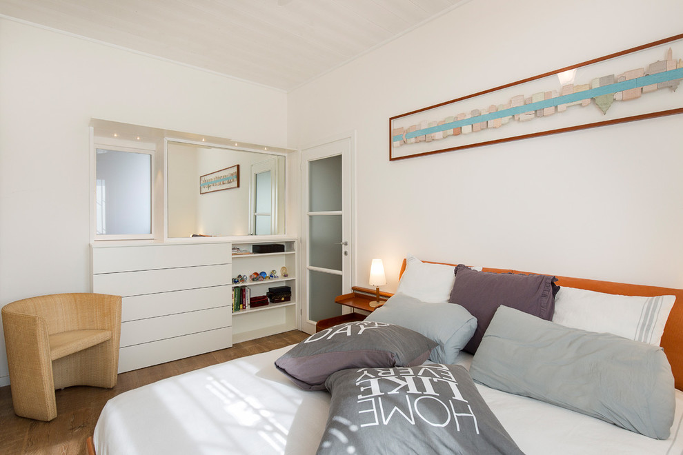 Immagine di una camera matrimoniale minimalista di medie dimensioni con pareti bianche e parquet chiaro