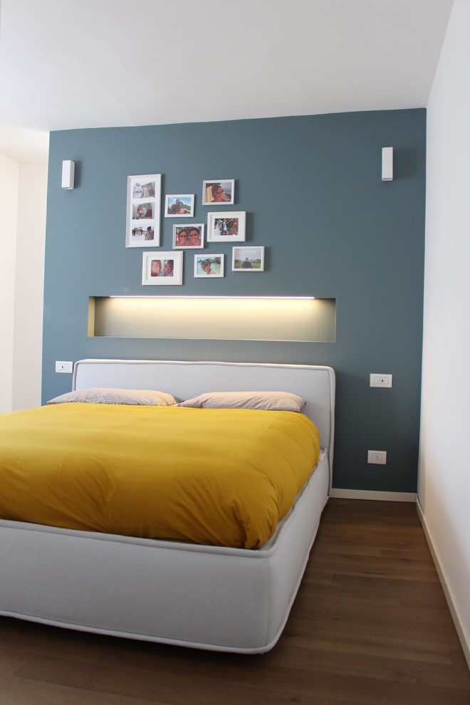 Ejemplo de dormitorio principal nórdico de tamaño medio con paredes azules y suelo de madera pintada
