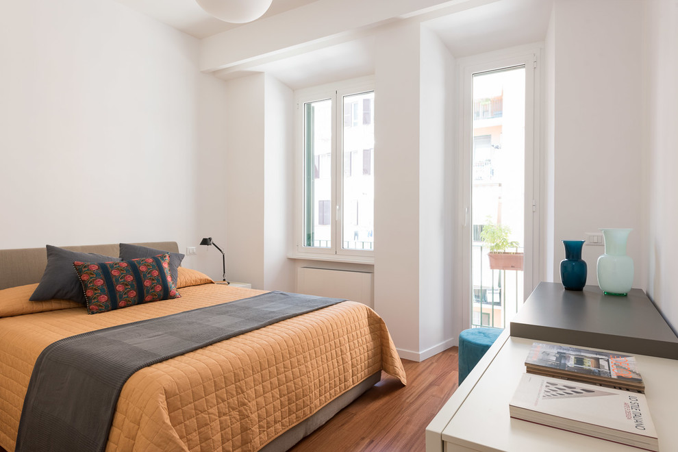 Modernes Gästezimmer mit weißer Wandfarbe, braunem Holzboden und braunem Boden in Rom