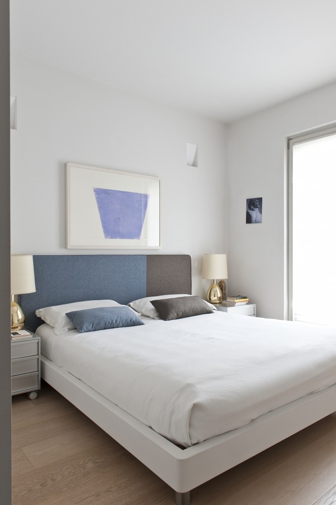 Mittelgroßes Modernes Hauptschlafzimmer mit weißer Wandfarbe und hellem Holzboden in Mailand