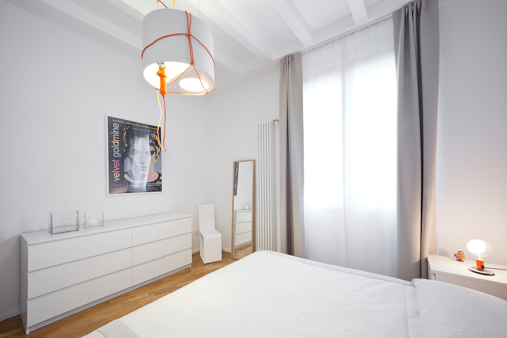 Immagine di una camera matrimoniale minimal con pareti bianche e pavimento in legno massello medio